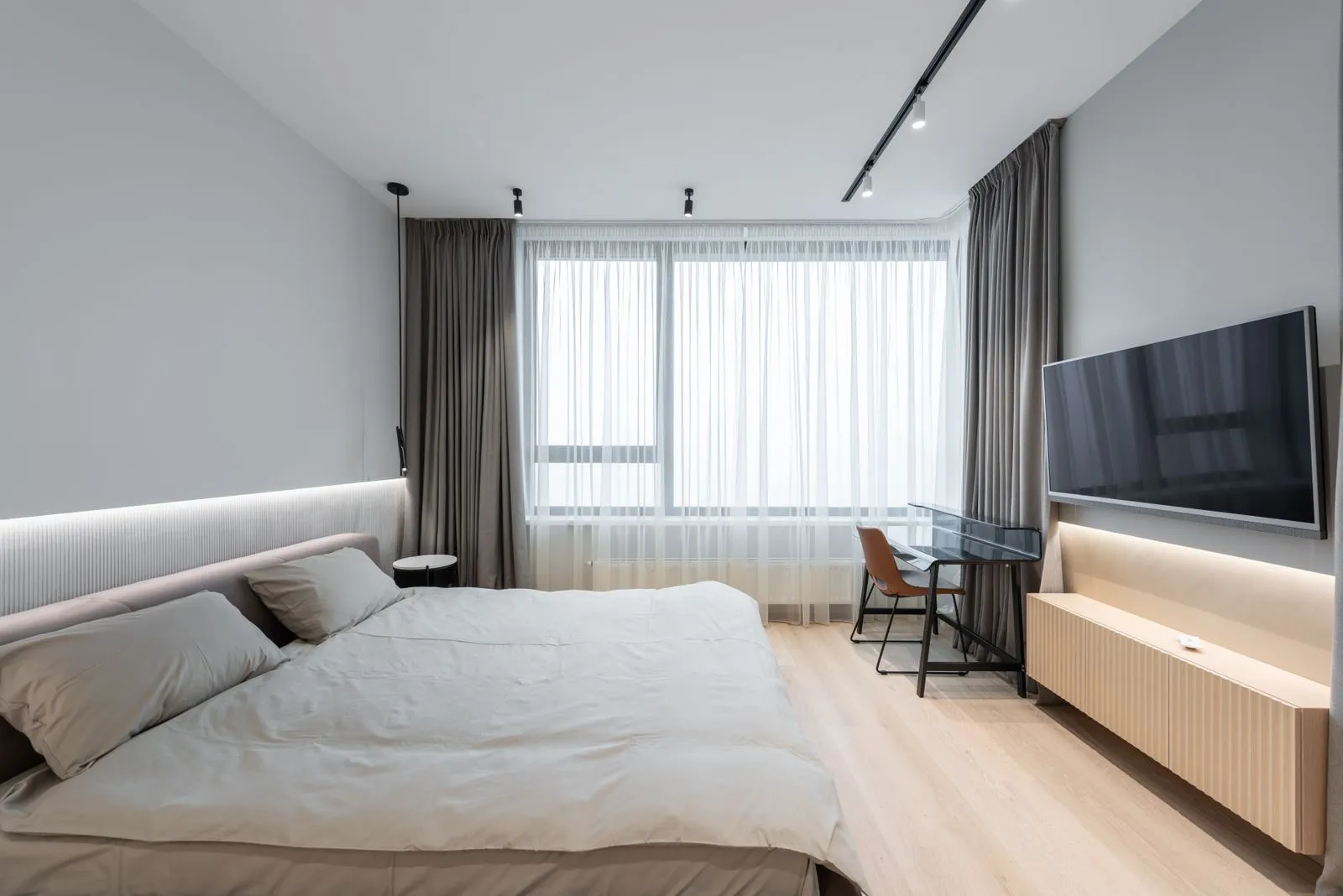 Dormitorio moderno con tira LED en el cabecero y bajo el mueble de la televisión