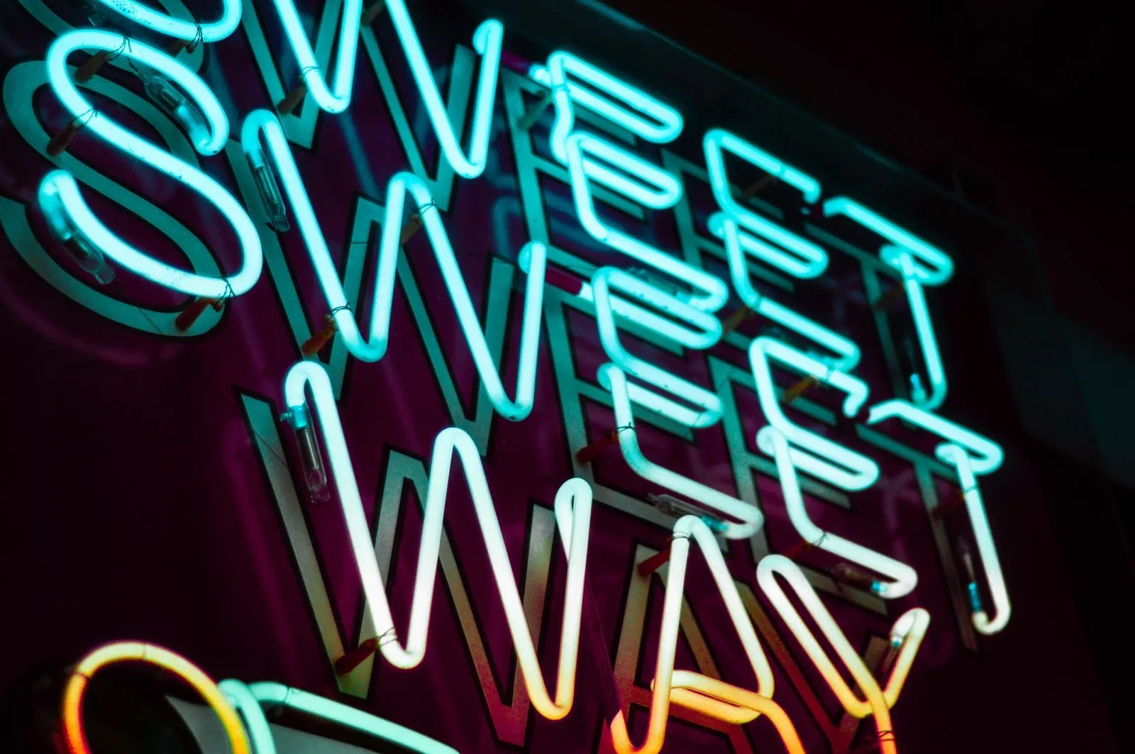 Letras de neón LED azul turquesa encendidas en una pared