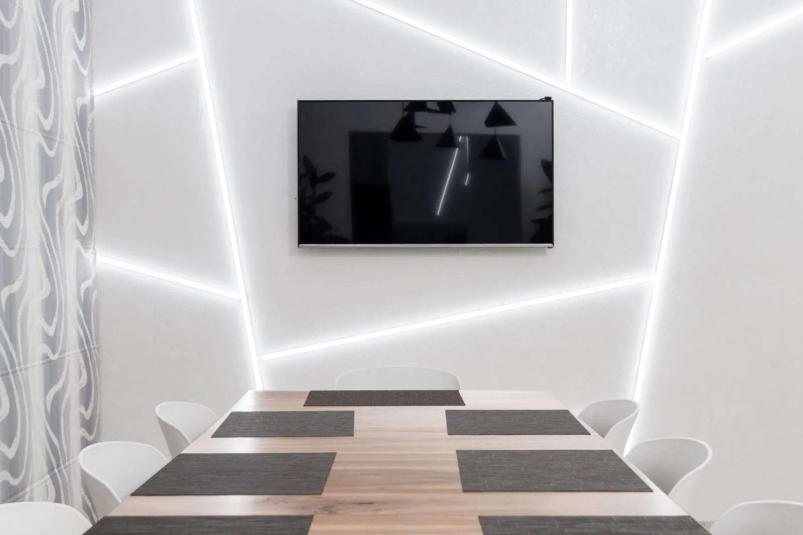 Comedor con líneas de luz LED en paredes y techo formando un dibujo geométrico