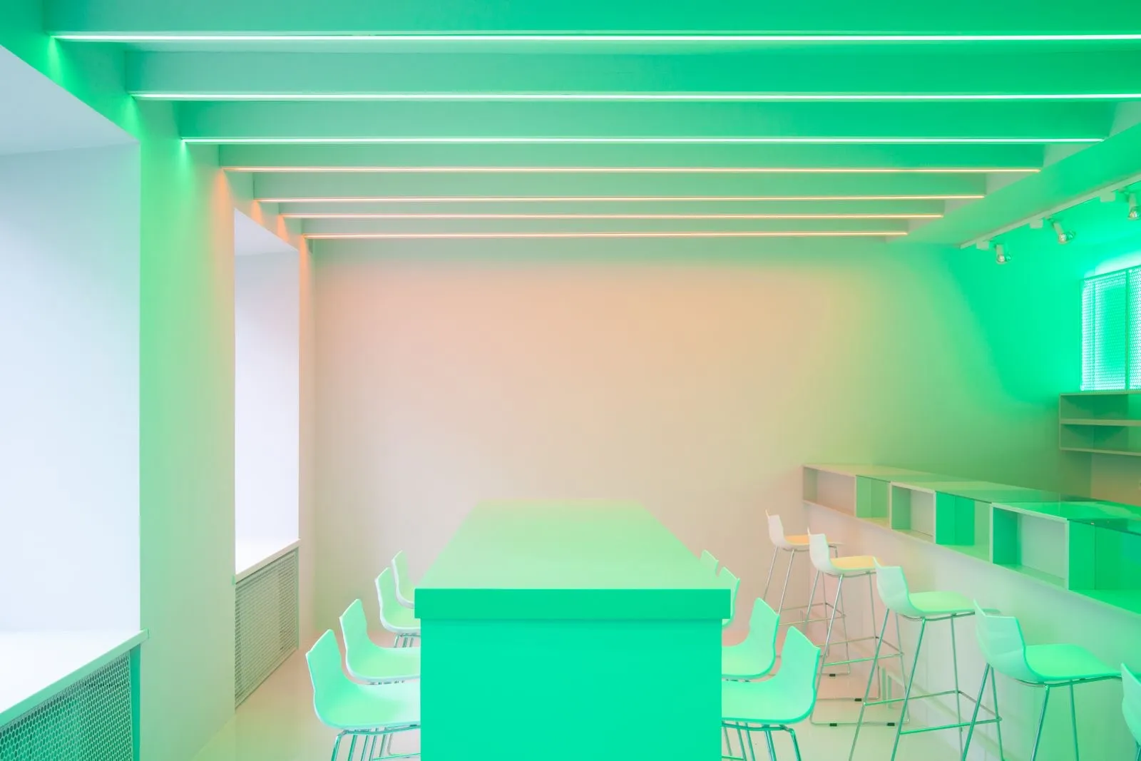 Sala con tiras LED inteligentes en el techo que bañan el espacio de verde