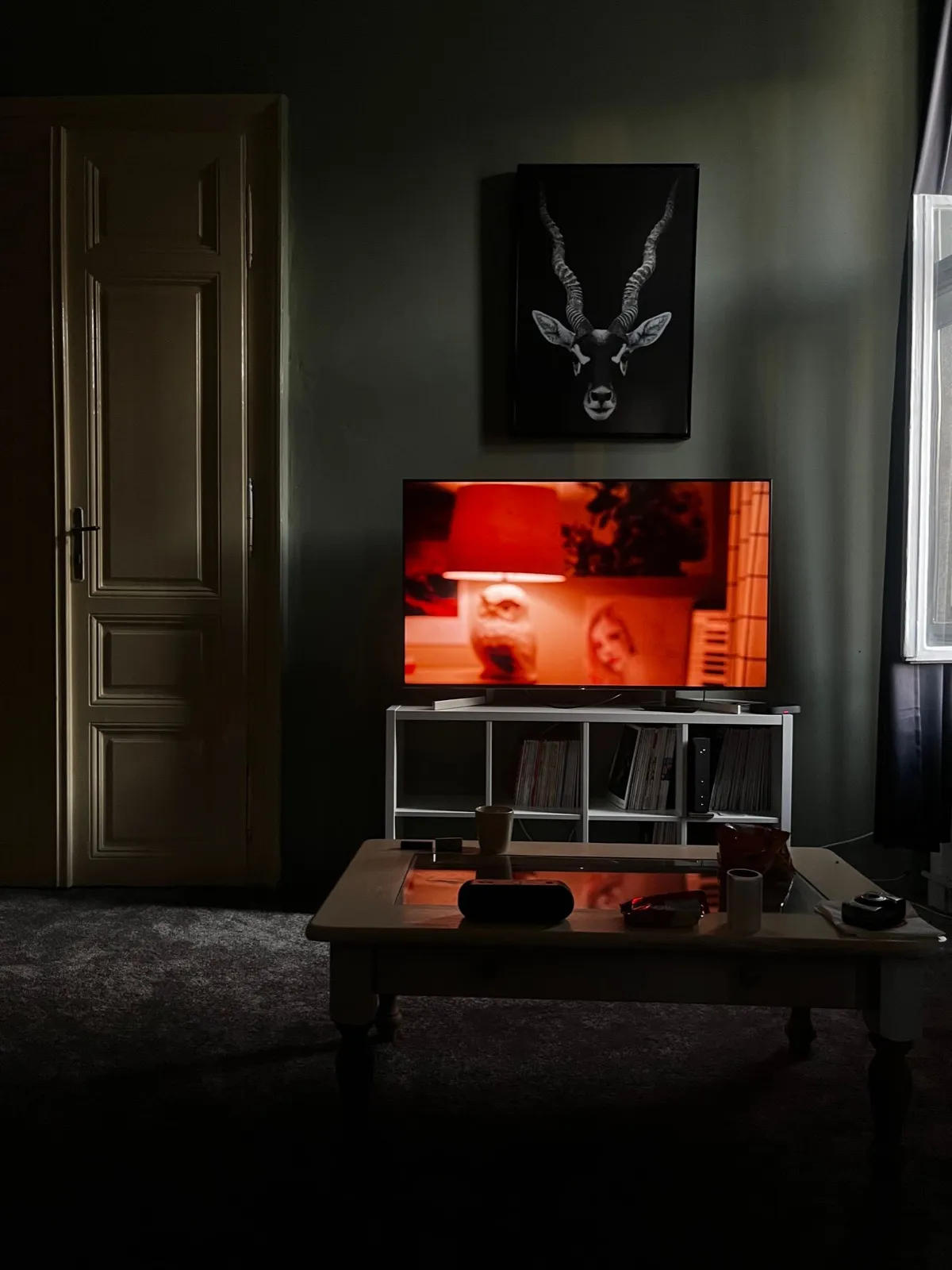 Salón oscuro con el televisor encendido como única fuente de luz ambiental