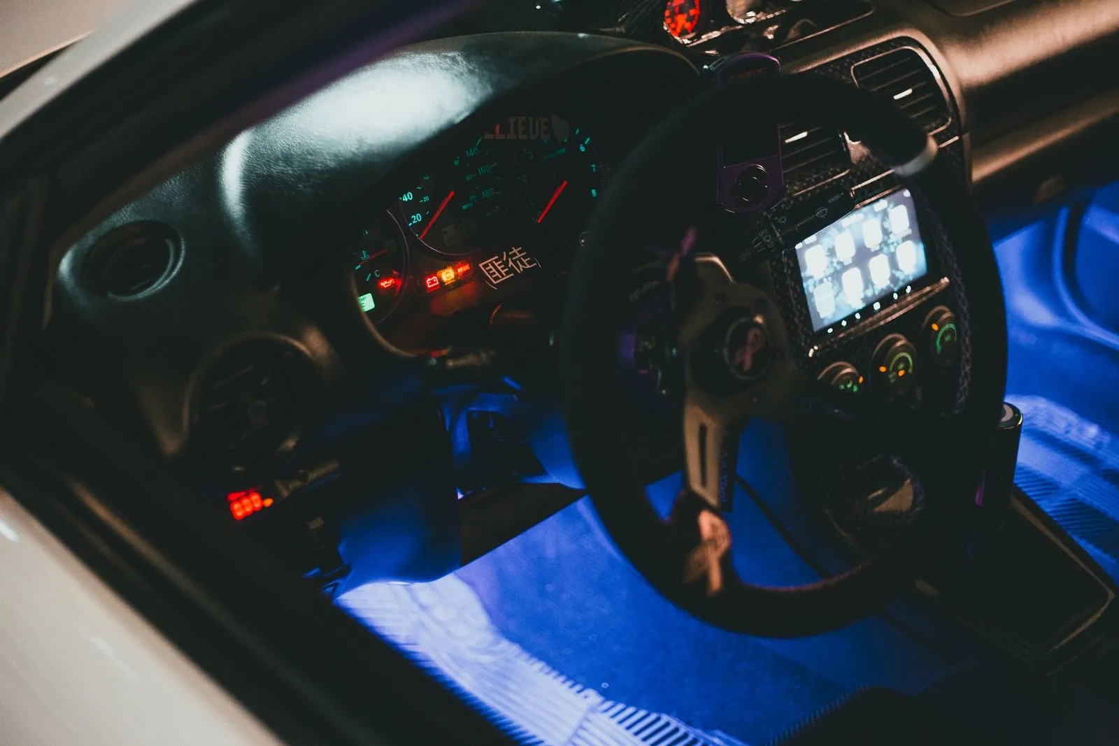Interior de un coche de noche con luz LED azul bajo el salpicadero