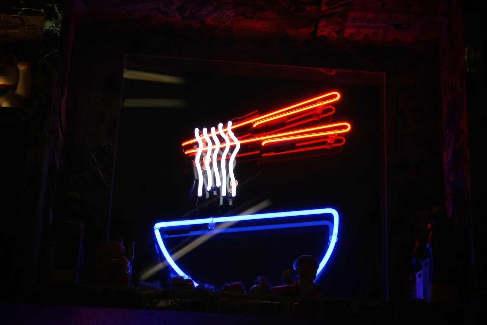 Cartel neón LED con un bol de fideos y palillos en un escaparate