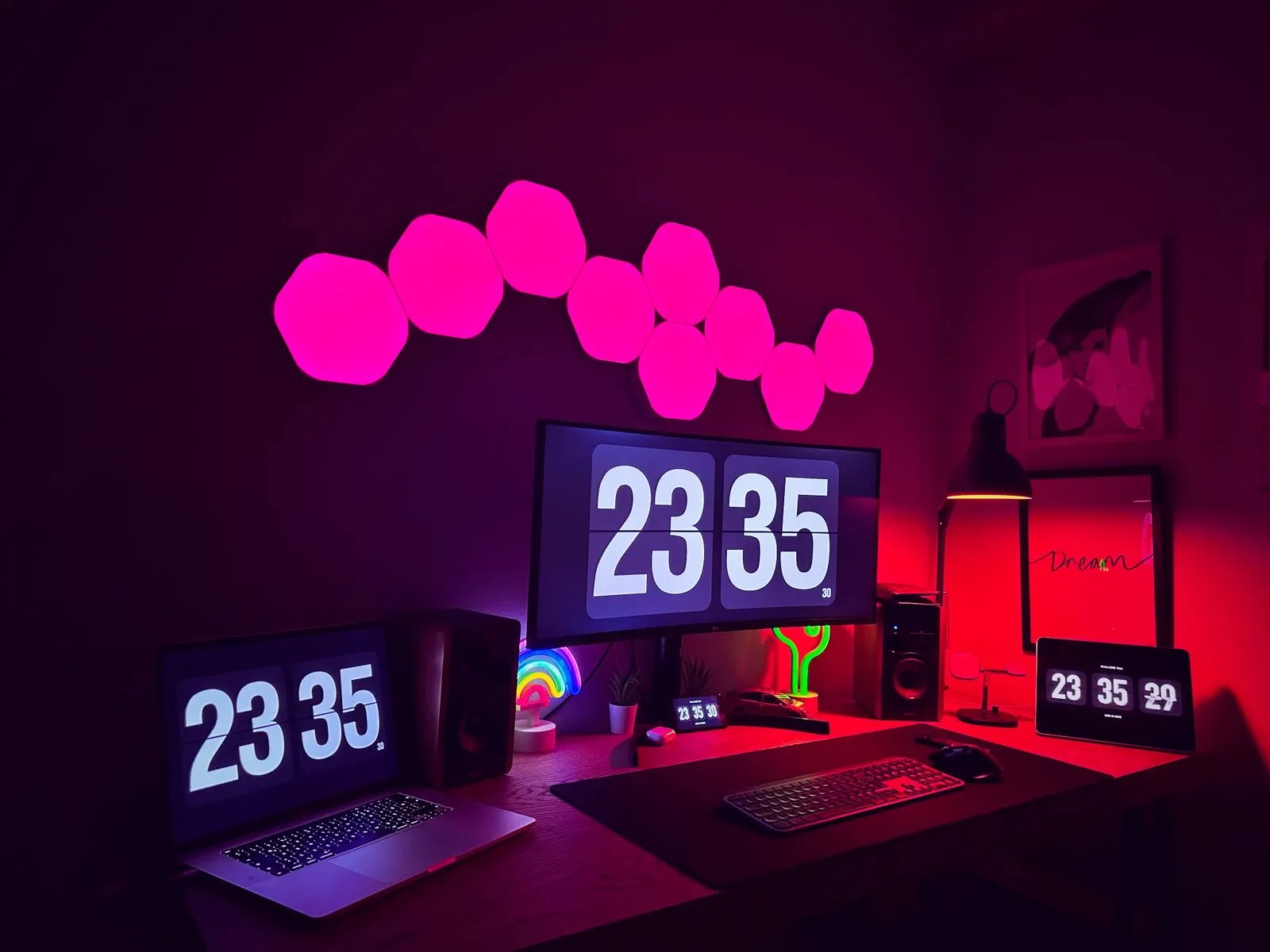 Escritorio con paneles de luz hexagonales rosas en la pared y luces inteligentes de colores